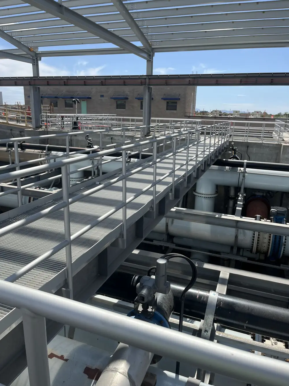 Aluminum guardrail along an elevated grating walkway above a pressurized pipe gallery at a water treatment plant