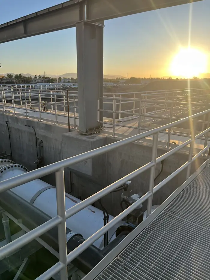 Aluminum guardrail around concrete basins at a water treatment plant at sunset
