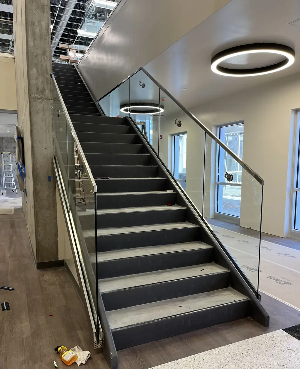 Finished stair with glass guardrail and brushed stainless cap rail at Career Tech High School