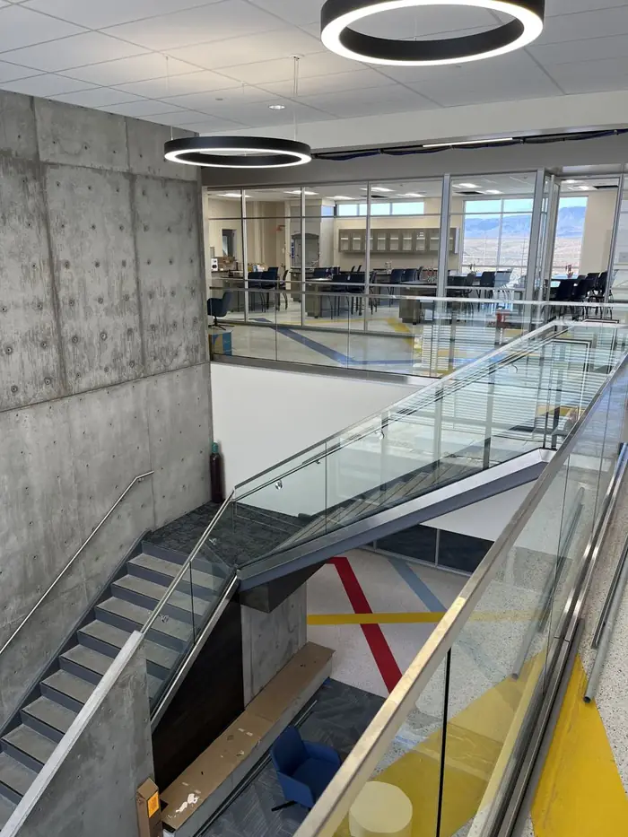 Glass guardrail along the upper edge above the main stair and commons