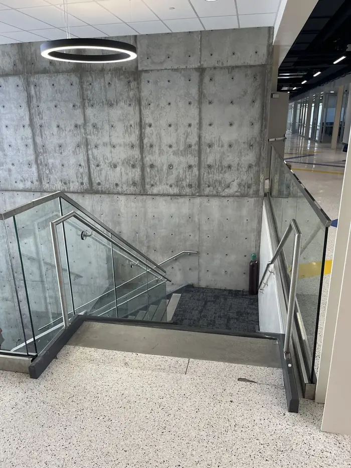 Glass guardrail turning the corner down a stair run with stainless handrail