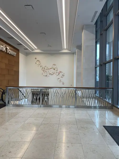 Wide view of the finished KeyBank Tower lobby with the stainless grass-motif guardrail along the balcony