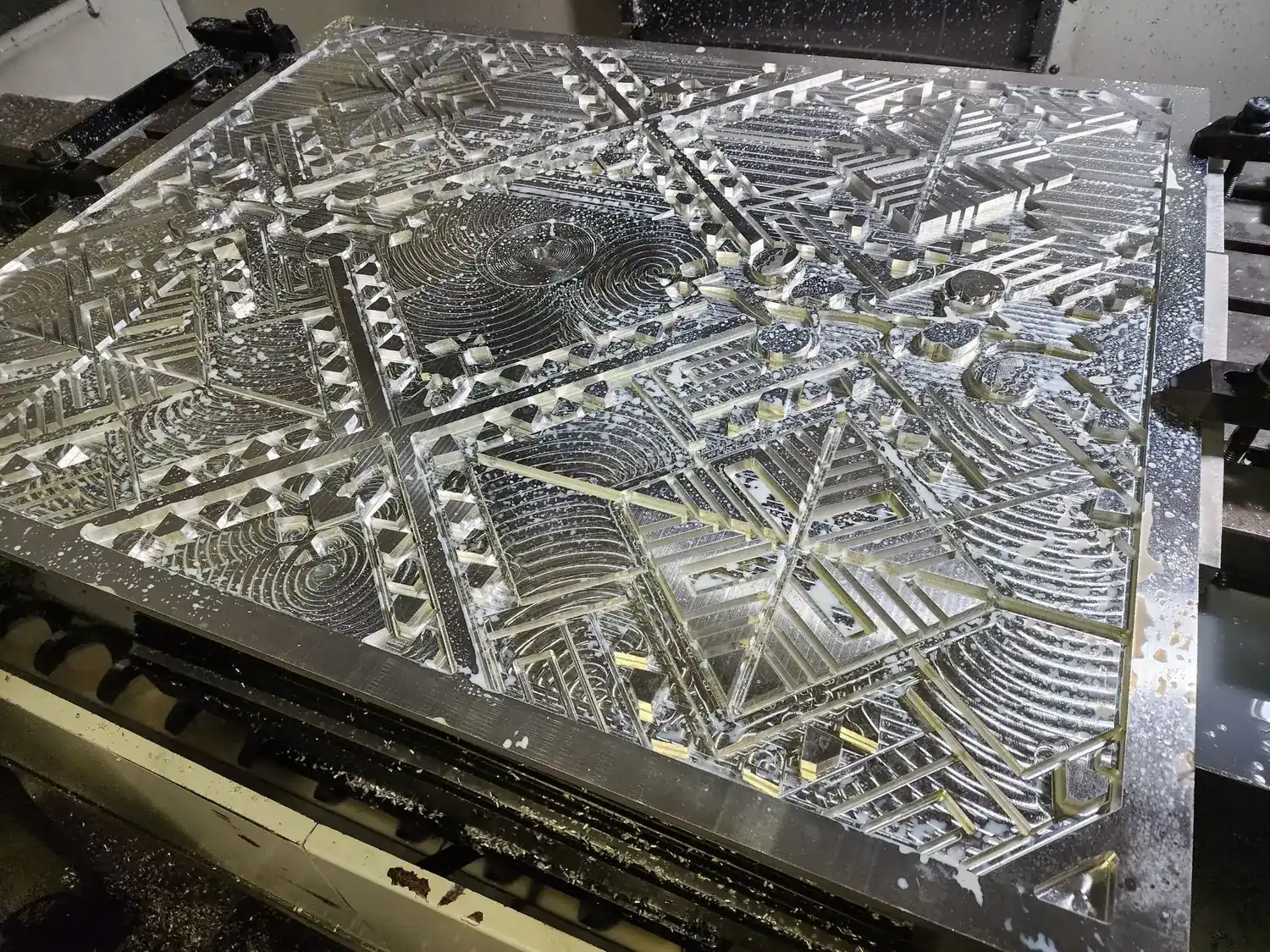 A large aluminum panel with its geometric relief pattern cut into solid plate