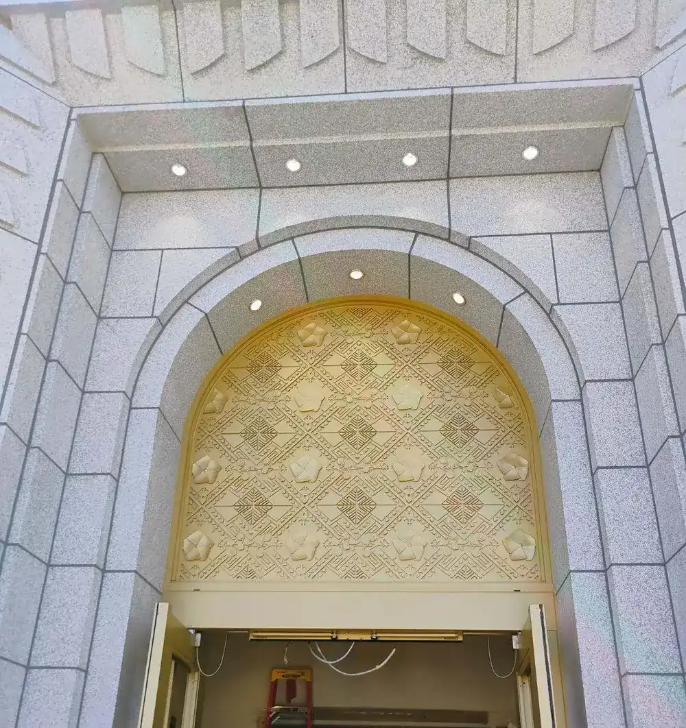 The finished arched transom above the temple entrance, the pattern running unbroken across the full width