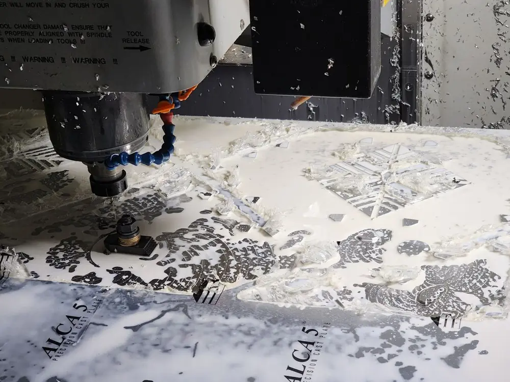 The cutter working a panel, chips covering the machine bed