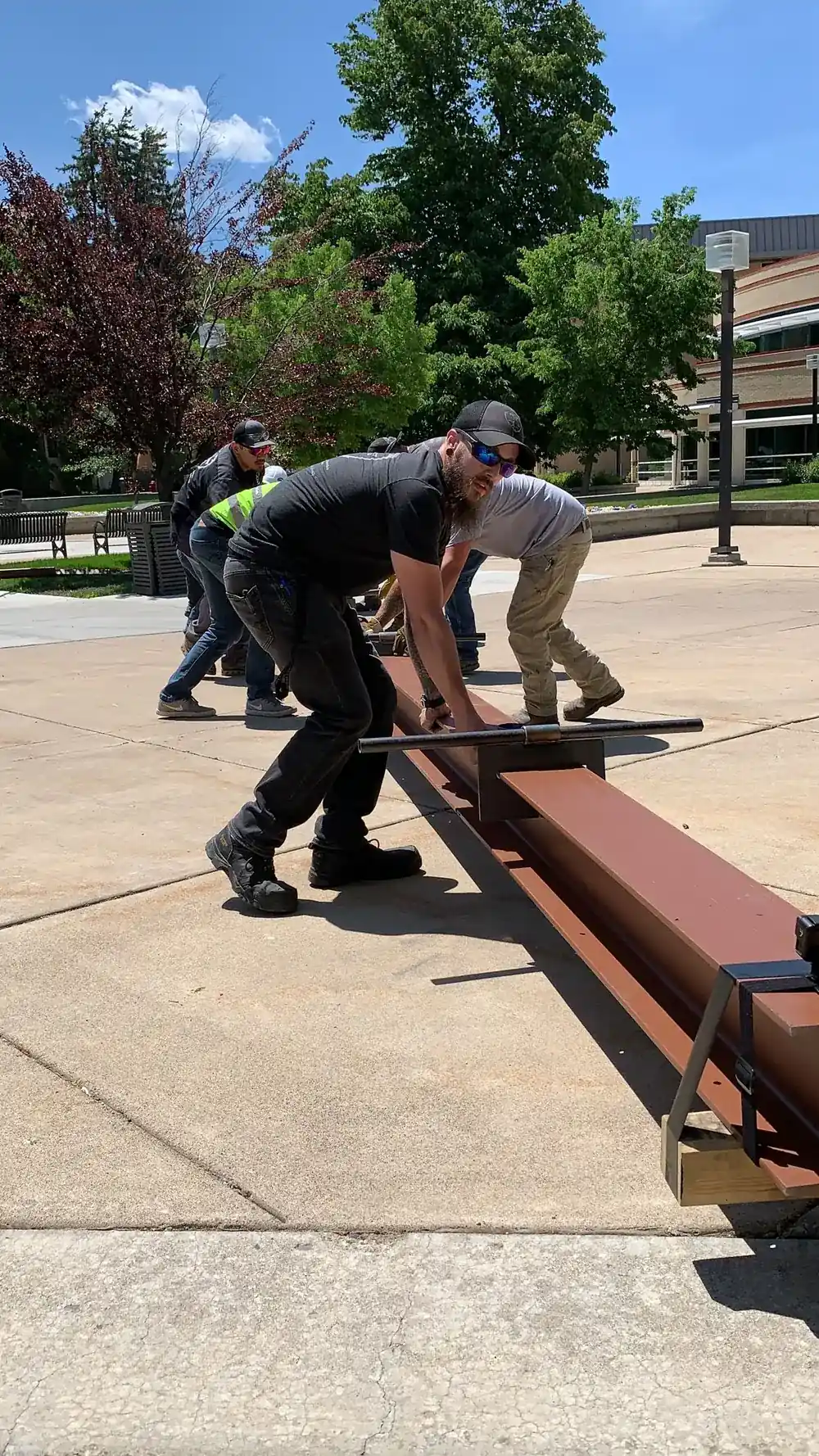 Zach Arnold and the crew moving a steel section across the plaza at the USU Taggart Student Center