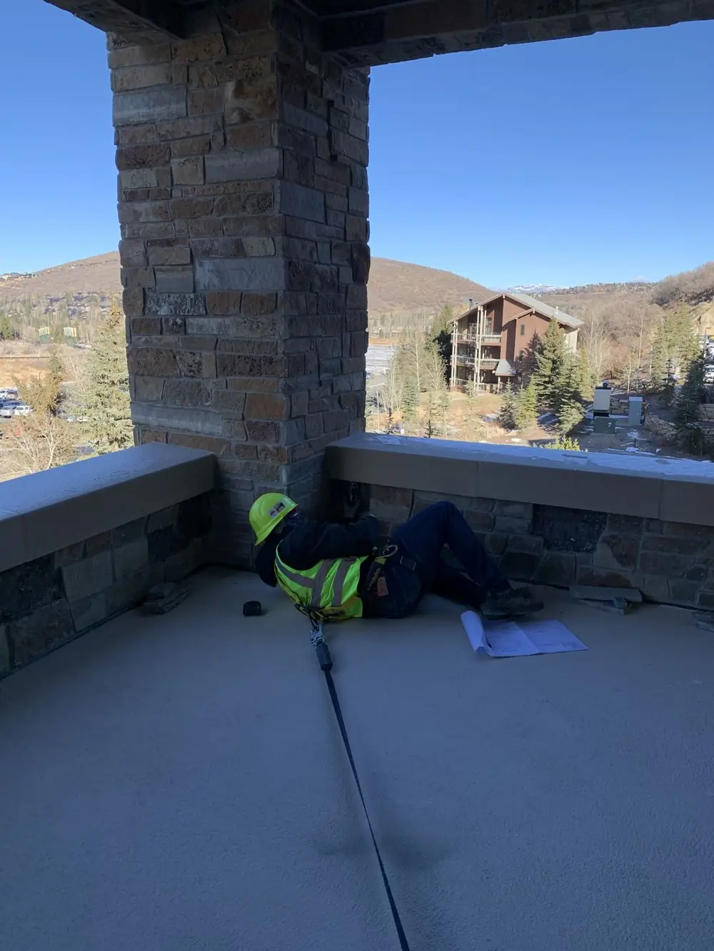 A crew member working at the base of a balcony guardrail on an open deck