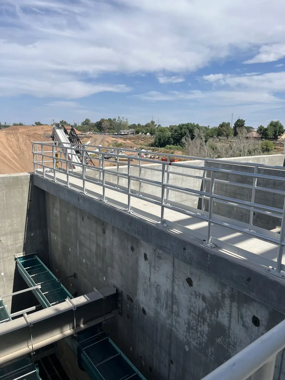 Installed aluminum guardrail along the edge of a deep concrete basin at a water treatment plant