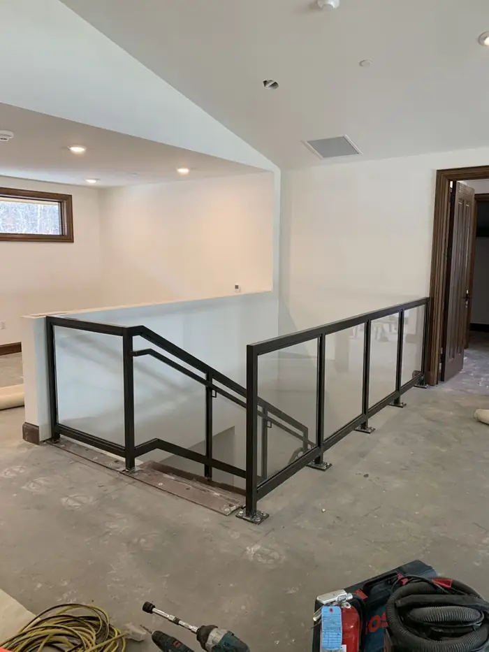 Glass infill guardrail at an interior stair in a residence