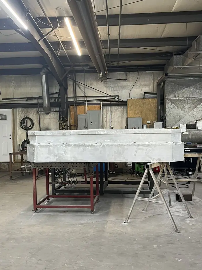 The cupola base weldment on stands in the fabrication shop
