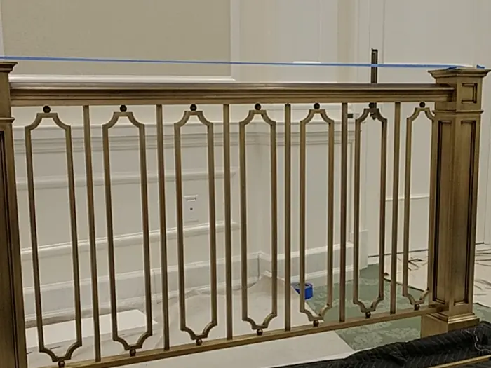A finished architectural bronze baptistry railing panel on the shop floor