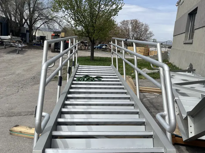 A complete aluminum stair with integral handrails, finished and staged outside the shop