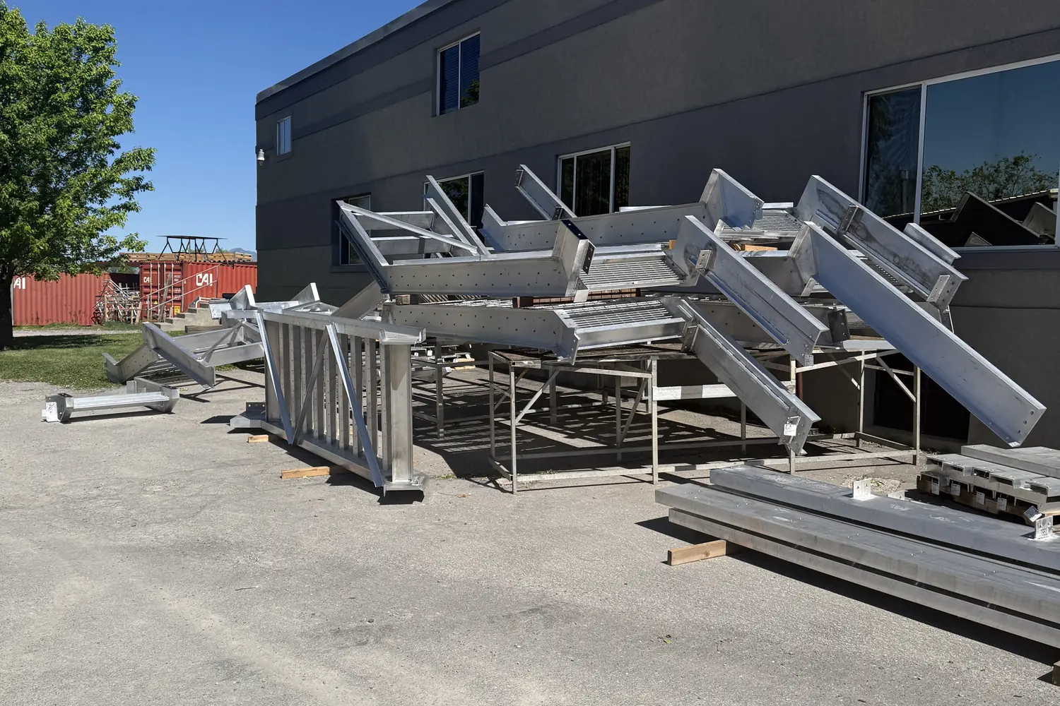 Finished aluminum stair assemblies staged in the yard outside the Logan shop, ready to load