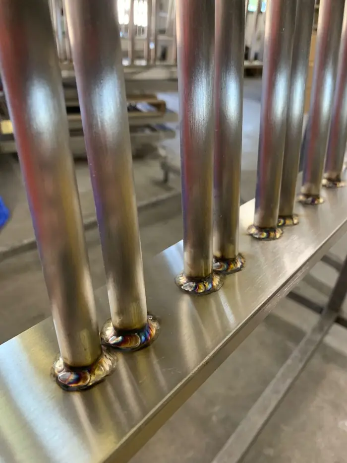 Oxide heat tint around stainless baluster welds before finishing