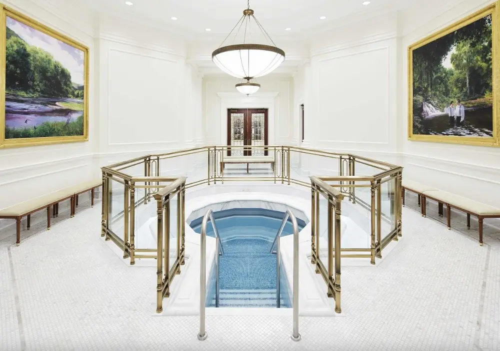 Completed architectural bronze baptistry guardrail with glass infill panels surrounding the font