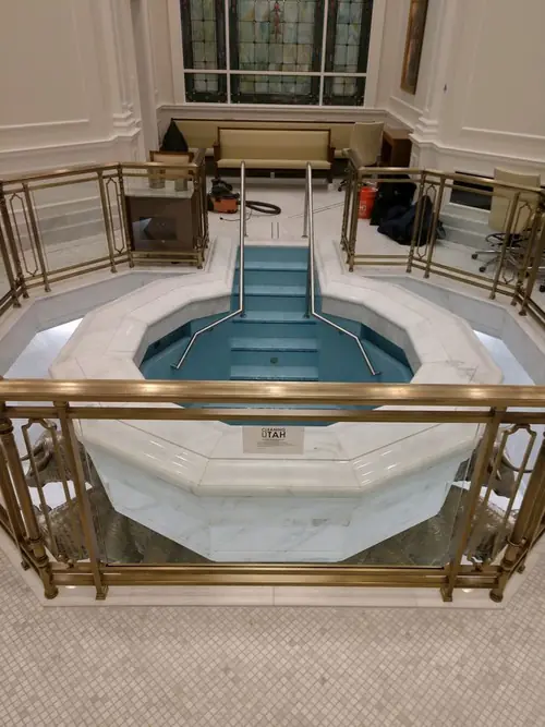 Bronze baptistry guardrail with glass infill panels installed around the font