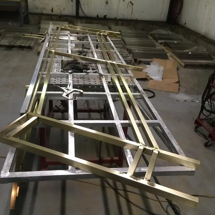 Bronze panel frames with glass infill assembled on the shop fixture table