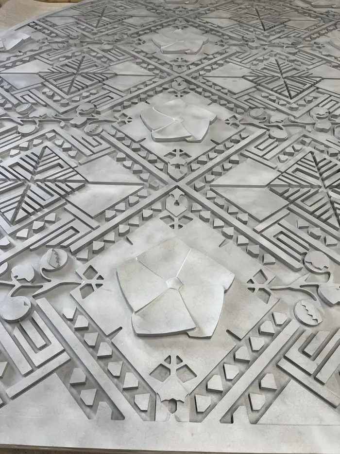 Close detail of a machined relief panel in cast aluminum under a coated finish