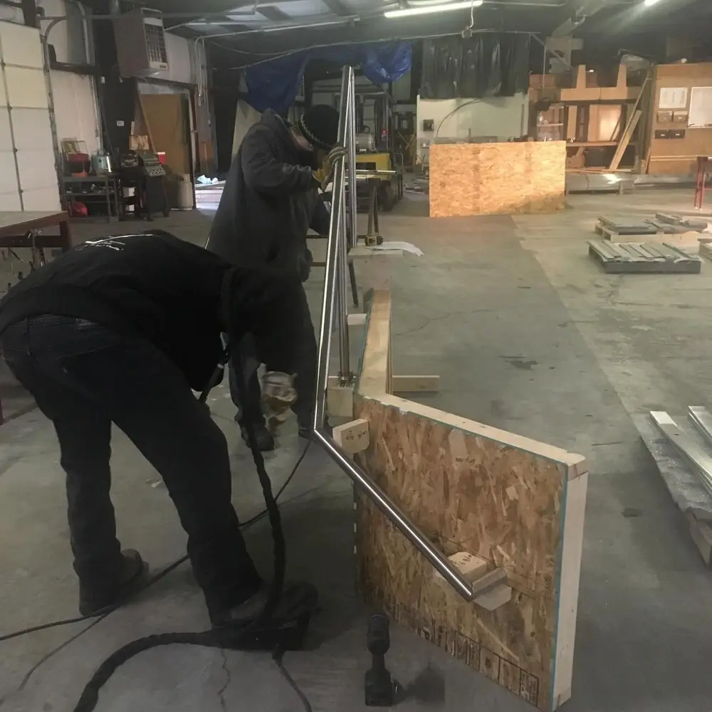 Craftsman hand-finishing a rail section on the shop floor