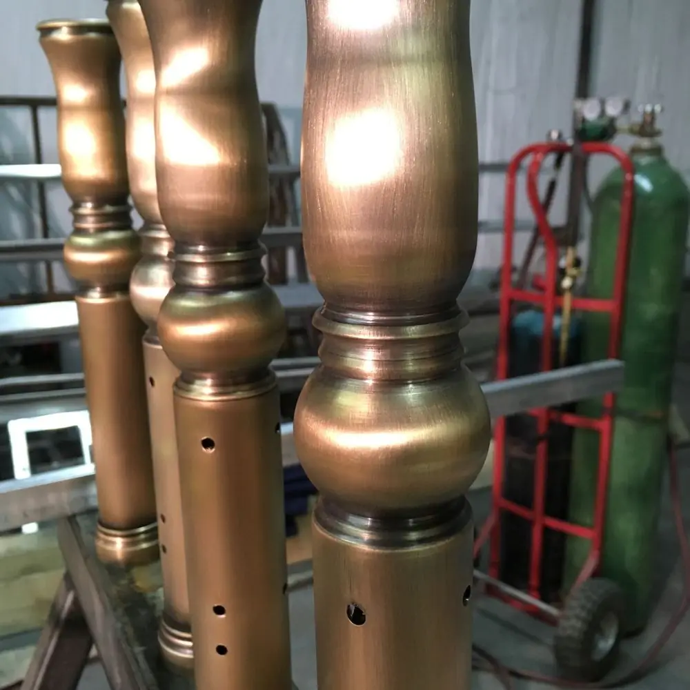 Turned architectural bronze newel components standing in the shop during fabrication