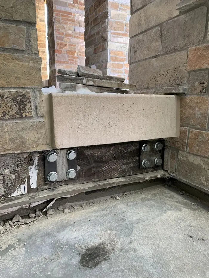 Anchor detail at the edge of a cantilevered balcony deck showing the fastened base condition