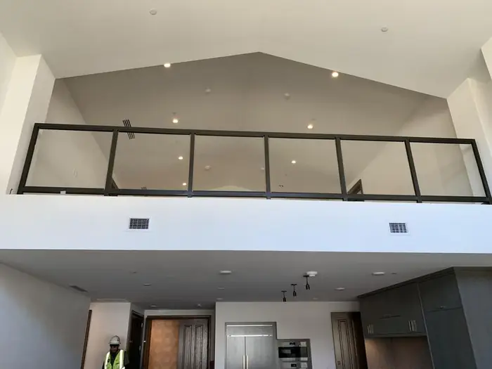 Interior guardrail with glass infill at a mezzanine opening
