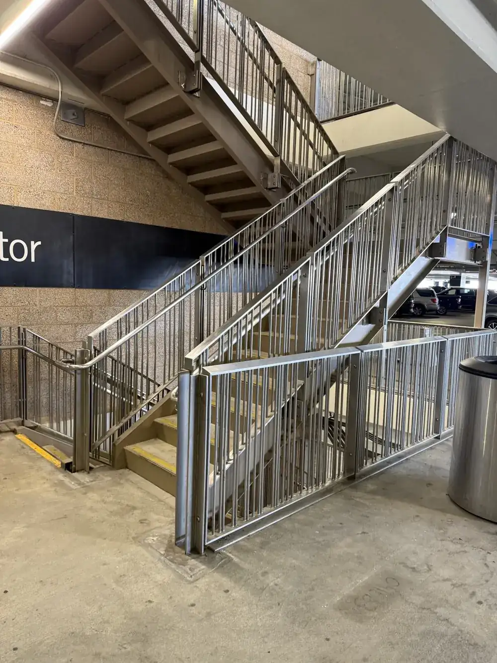 Completed 304 stainless steel guardrail and handrail on a stair run inside the Salt Lake City International Airport parking structure