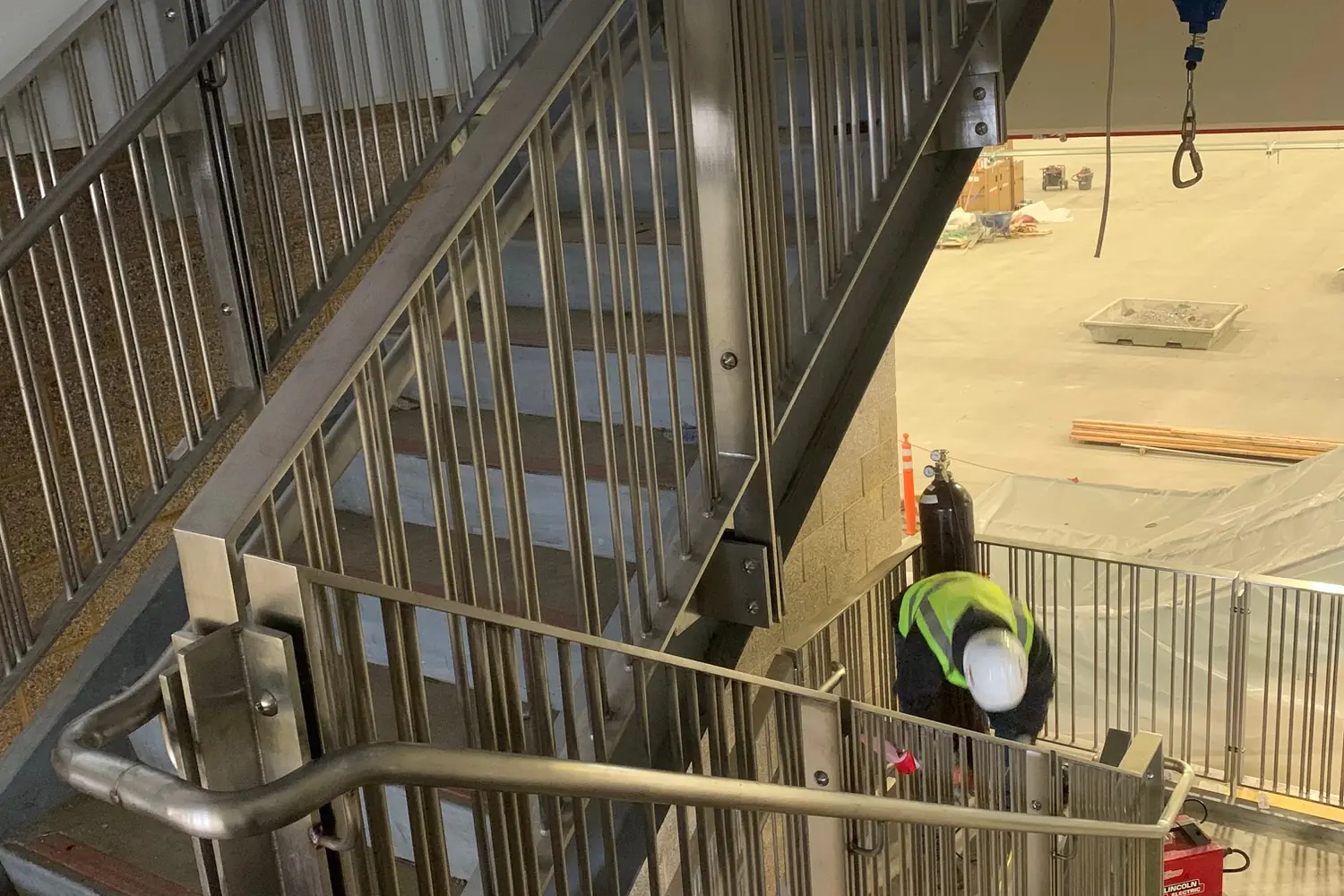 Stainless guardrail and handrail turning down an open stair in the airport parking structure