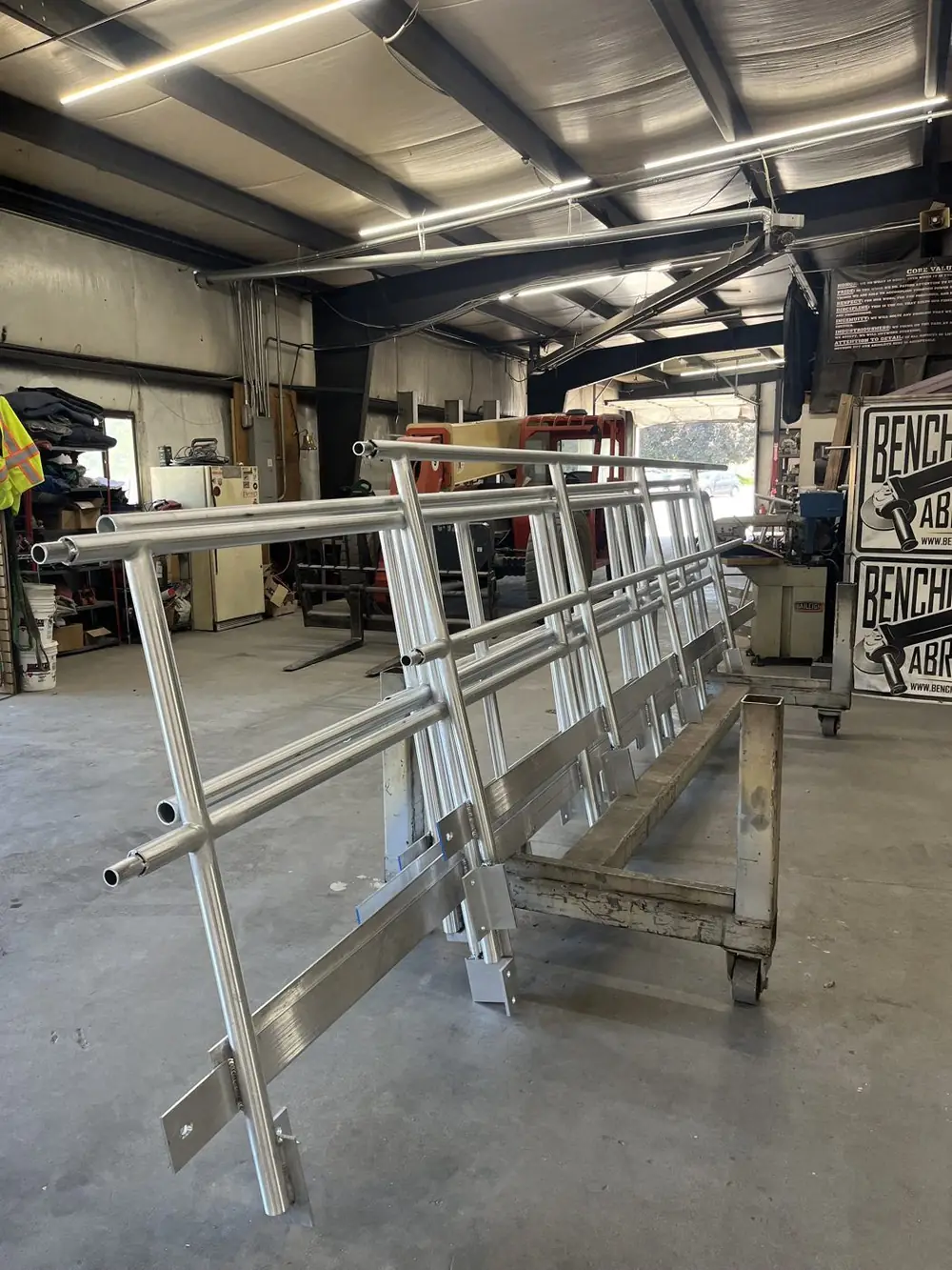 Assembled anodized aluminum guardrail section standing on a cart in the Arnold Quality shop